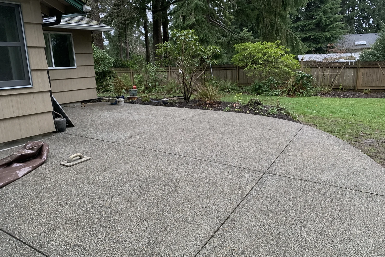 Completed drainage-pitched exposed aggregate patio Redmond Washington King County Eastside Pacific Northwest residential Kevin